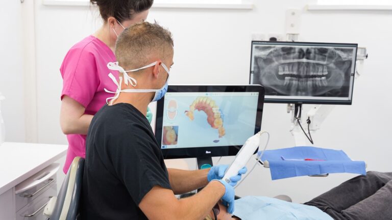 Dentist uses an intraoral scanner to capture a 3D image of a patient's teeth during orthodontic treatment at Pure, with digital X-ray visible in the background.