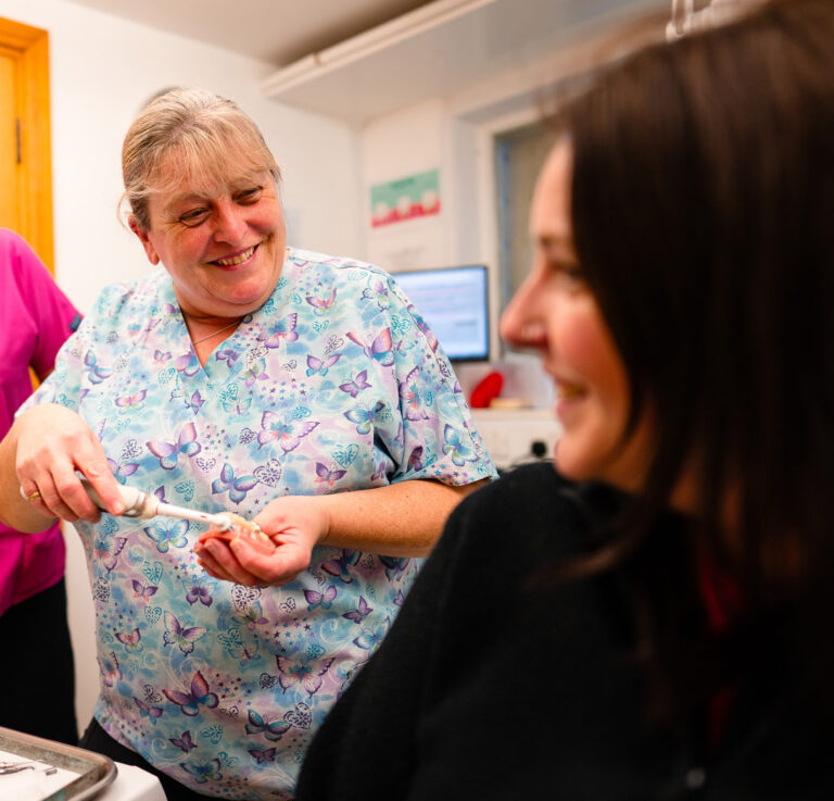 A dental hygienist advises a patient on tooth brushing techniques at the Pure Dental surgery in Truro, Cornwall.