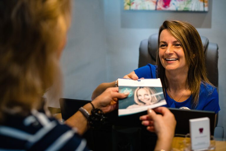 Receptionist handing patient a leaflet