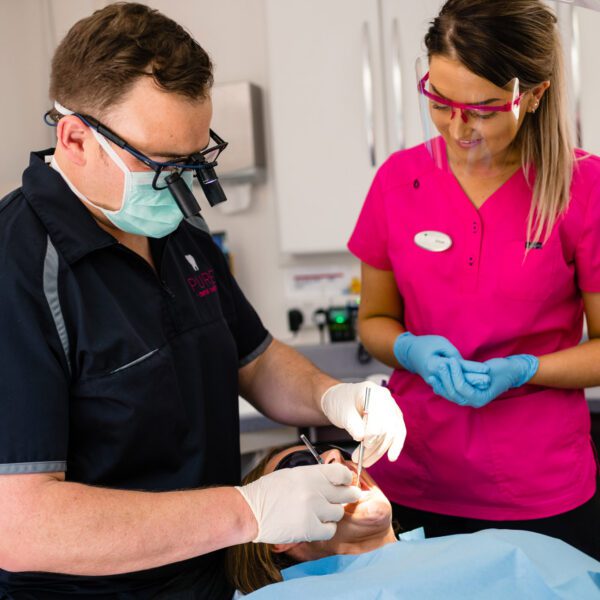 Pure Dental Looking At Patients Teeth with a tooth abscess