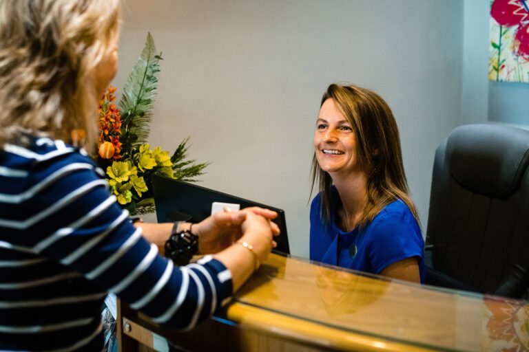Receptionist Assisting Patient